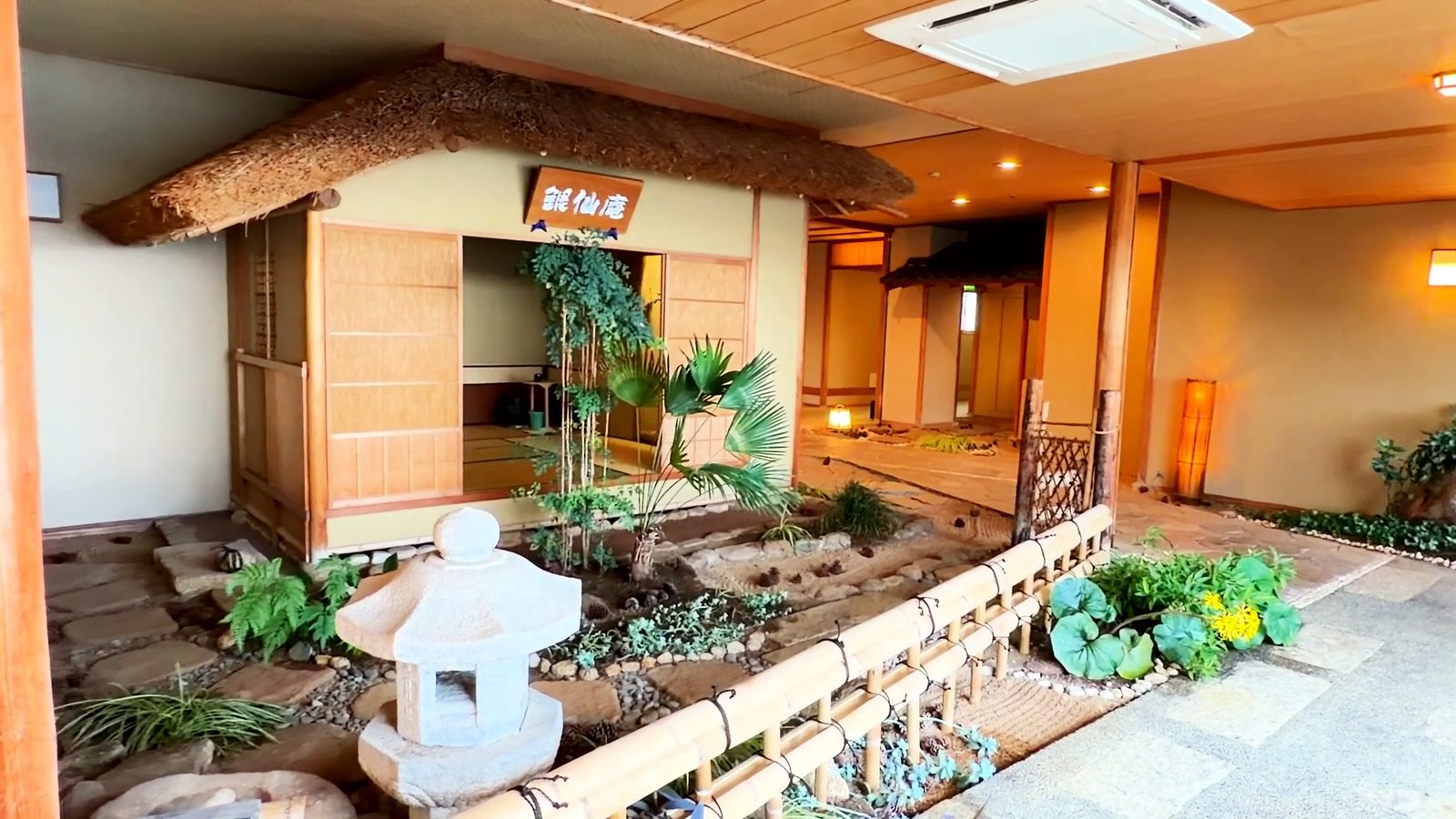 10階の館内のお庭。石灯籠と茅葺き屋根の小屋