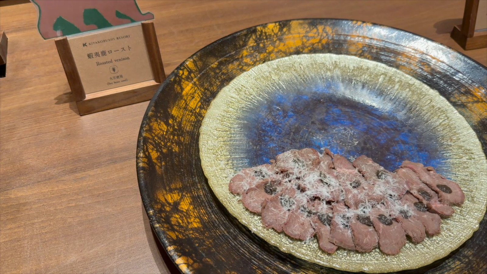 大皿に盛られた蝦夷鹿のロースト。横に料理名の札