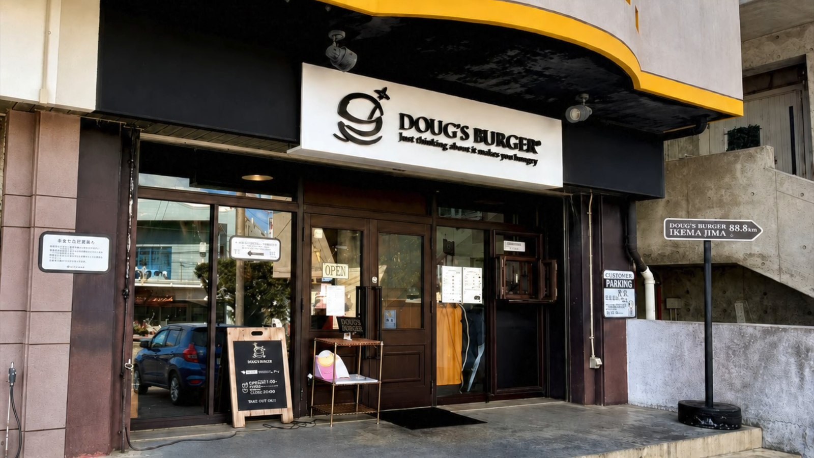 ダグズバーガーの外観。黄色い庇と黒い看板