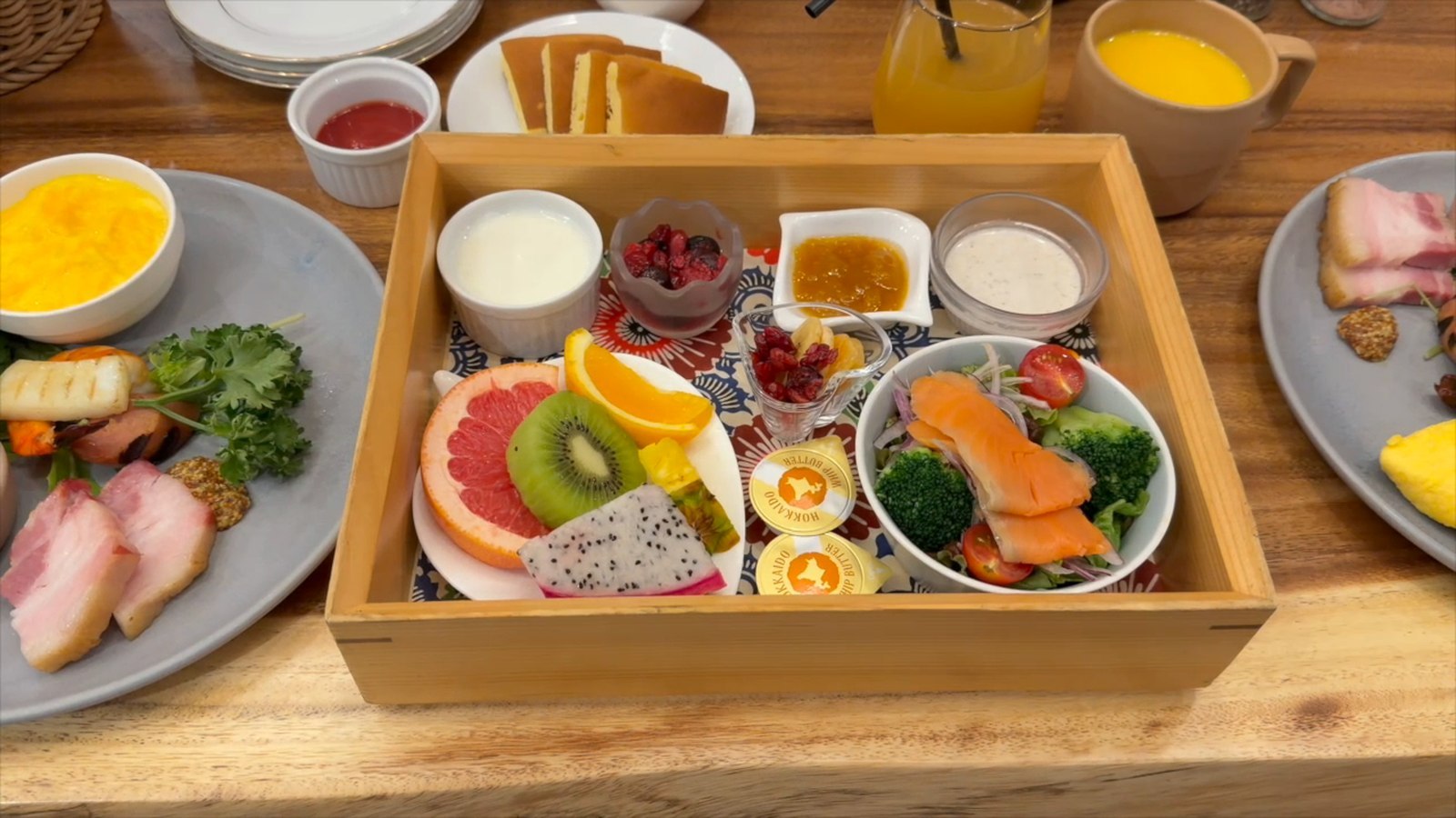重箱に盛られた洋食の朝食とオレンジジュース