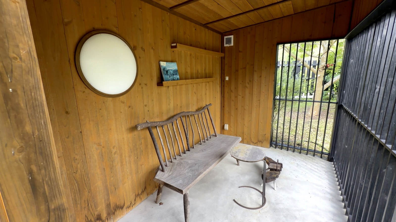小屋の中の丸い窓と木のベンチ